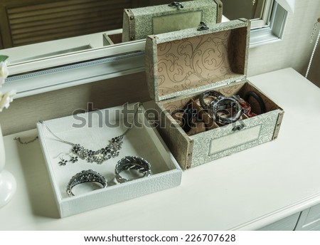 Beauty and make-up concept: mirror,jewelry and makeup box on a table