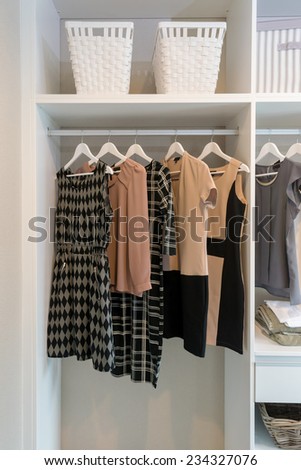 row of dress hanging on coat hanger in white wardrobe