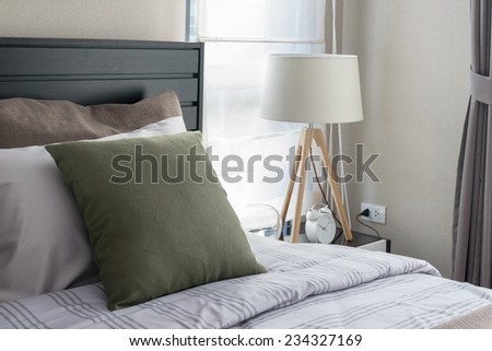 modern bedroom with green pillow and wooden lamp