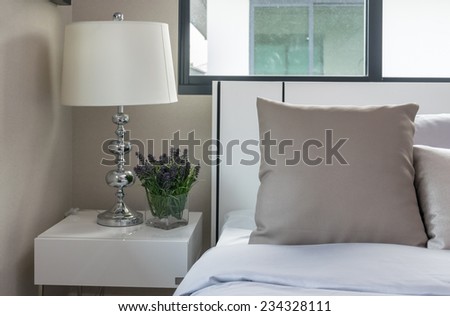 bedside lamp and plants in vase in bedroom