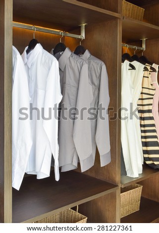 row of white and gray shirts  hanging in wooden wardrobe