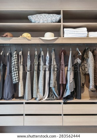 modern closet with row of dress hanging on coat hanger in wardrobe.
