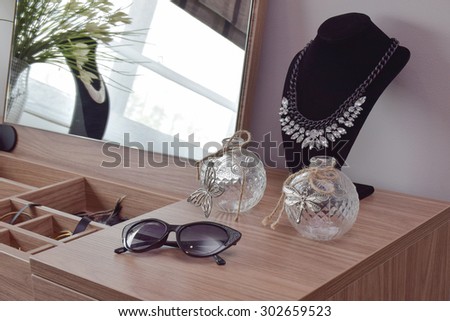 Sunglasses crystal jars and necklace on dressing table