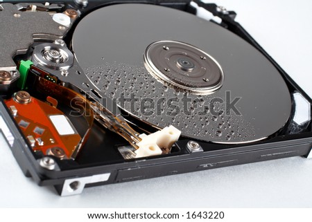 Close-up of the opened hard disk drive, with water drops