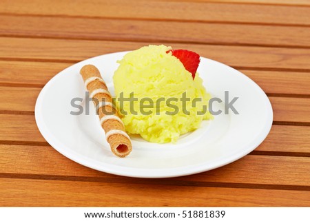Delicious vanilla ice cream ball on white dish. Shallow depth of field