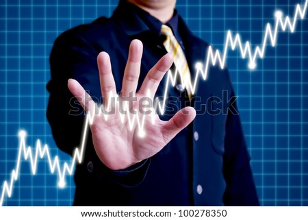 Business man reaching for a graph of stock market
