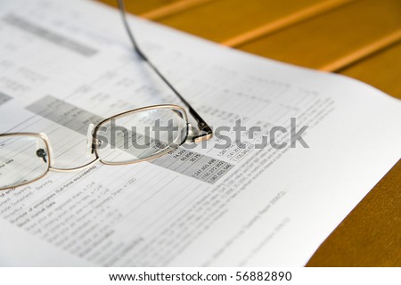 Glasses on a quarterly report, shallow depth of field