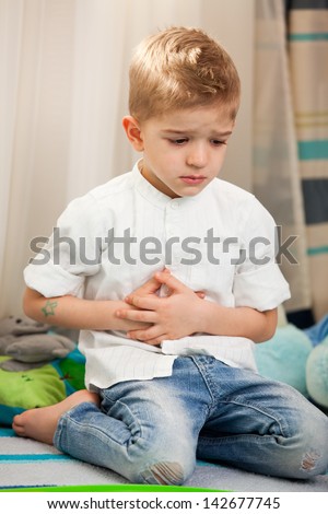 A five year old child having an abdominal pain. A five year old child having a pain in the belly, holding hands over