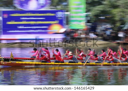 PRATUMTHANI, THAILAND - OCT 28: Panning shot of two rowing teams in full speed during Long-tailed Boat Competition for Royal Championship Cup on October 28, 2012 in Rangsit, Prathumthani,Thailand.