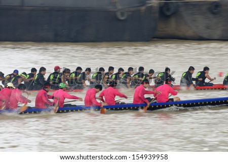 BANGKOK, THAILAND - AUG 25: Two rowing teams in full speed during Thai Long-tailed Boat Competition along Chaopraya river on August 25, 2013 at Rama 8 Bridge, Bangkok, Thailand