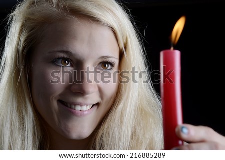 beautiful young blond woman with burning candle
