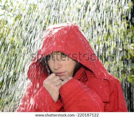 freezing young woman with hood standing in the rain