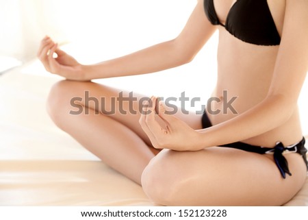 Portrait of young woman meditating in pose of lotus. Yoga background