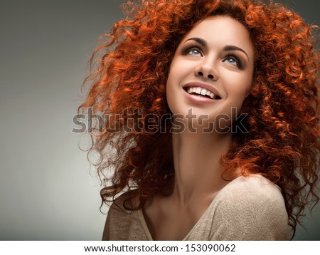 Red Hair. Beautiful Woman with Curly Long Hair. High quality image.