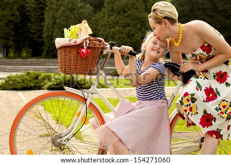 The Family in the Park on Bicycles. Happy Mother and Daughter