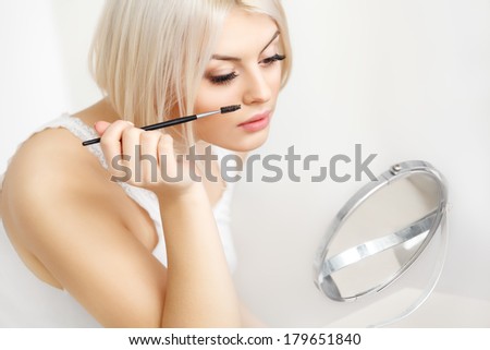 Beautiful Woman applying Mascara on Eyelashes. Eye Makeup