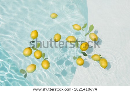 Pool Water With Lemons. Pure Aqua Surface With Glares Pattern And Floating Fresh Citrus. Clear Liquid With Sunlight Reflection In Summer.