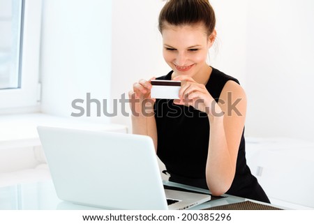 Happy Woman Holding a Credit Card and Shopping From the Internet