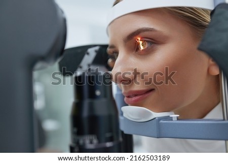 Eyesight Exam. Woman Checking Eye Vision On Optometry Equipment. Patient's Vision Check at Opticians Shop or Ophthalmology Clinic. Eye Clinic Treatment Concept Stok fotoğraf © 
