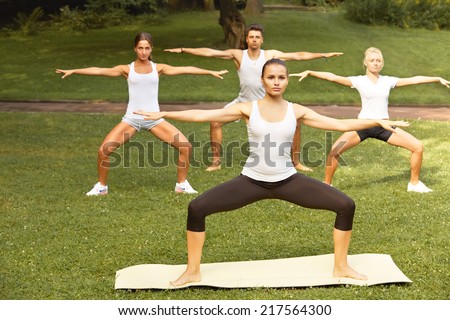 Fitness class. Portrait of smiling people doing fitness exercise at summer park