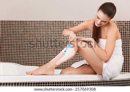 Long Woman Legs . Woman Shaving Legs in Bathroom