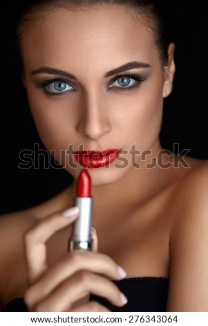Red lips.  Beutifull Woman Doing Makeup Applying lipstick