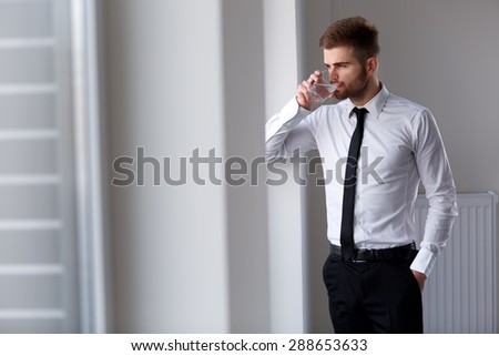 Businessman Thinking about Future of Company. Glass of Water