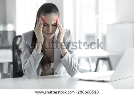 Headache and Stress at Work. Portrait of Young Business Woman at her Workplace