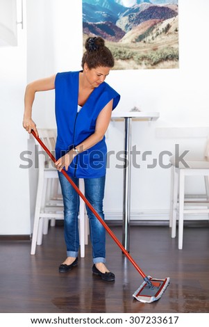 Portrait Of Young Woman Mopping Floor At Home . Cleaning Service