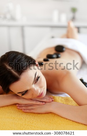 Spa Stone Massage. Young Woman Have Hot Stone Massage Treatments. Spa Hot Stones