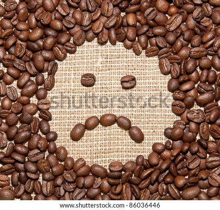 coffee beans sad smile on burlap background