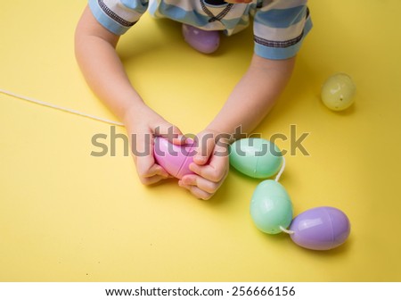 Kids easter activity and crafts: stringing plastic easter eggs for the egg hunt.