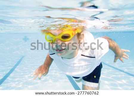 Child, kid, diving and swimming in pool underwater, summer or sports theme