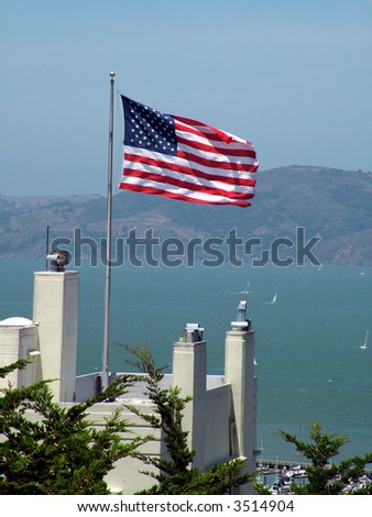 View of an American Flag over the San Francisco Bay, view of Alcatraz in the background