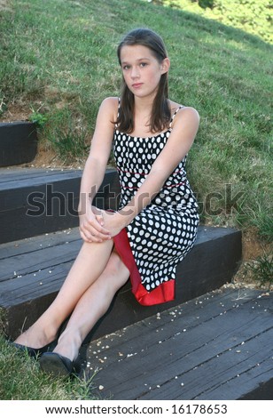 Portrait Of A Young Girl In A Dress Sitting On Steps In A Park, Outdoor ...