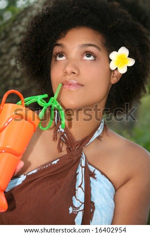 Portrait of a beautiful young female with hibiscus in her hair and a tropical drink, Hawaiian theme