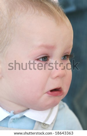 Baby boy with blue eyes and blond hair crying, portrait