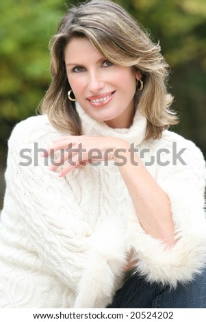 Winter or Christmas Holiday Theme: Gorgeous woman in a white sweater, portrait. Suitable for a variety of seasonal, advertising themes