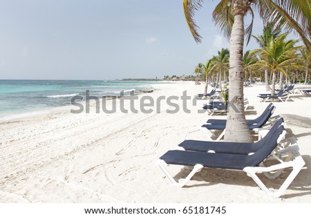 Empty white sand beach, ocean and palm trees in Mexico, Riviera Maya