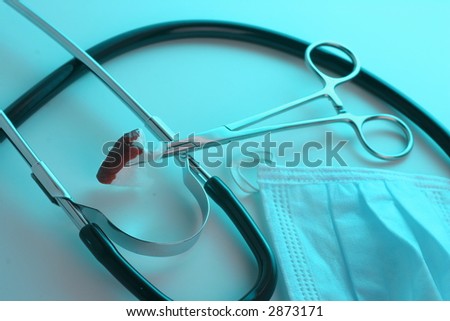 medical/surgical instruments on cool ground, and a bit of blood
