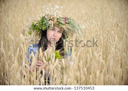 Closeup of a woman with a flower crown in the wheat field