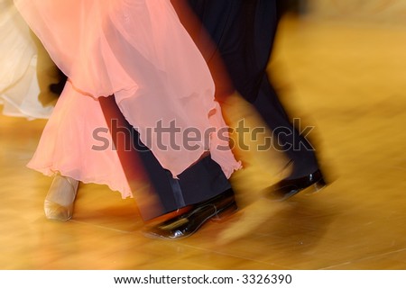 Man\'s dancing feet following dancing foot of woman wearing pink silky dress