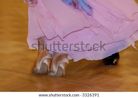 Two feet of woman dressed in lilac silky dress leaning against man\'s feet