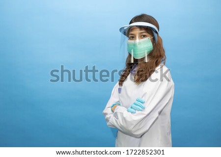 young attractive dentist wearing surgical mask and face shield. the written on her gown is he name in Thai alphabets Foto d'archivio © 