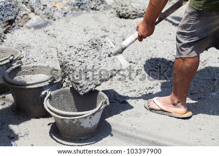 Worker pouring concrete to formwork at construction site