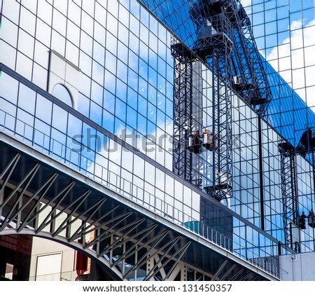 A man cleaning windows at Kyoto Station,It on a high rise building