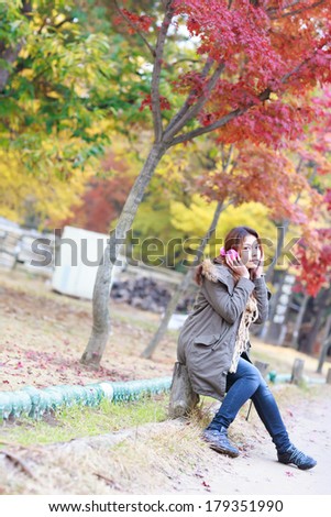 woman listening music outdoors in autumn season.