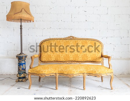 Yellow vintage sofa on white wall.