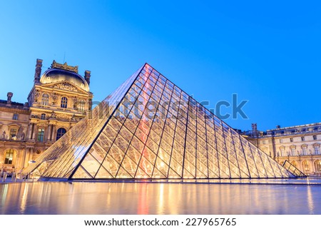 PARIS, FRANCE - JULY 19: The Louvre Pyramid at dusk during the Michelangelo Pistoletto Exhibition on July 19, 2014 in Paris. The Pyramid is the main entrance to the Louvre Museum.