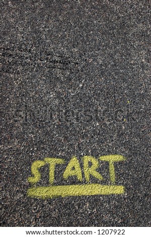 A yellow start painted on black pavement